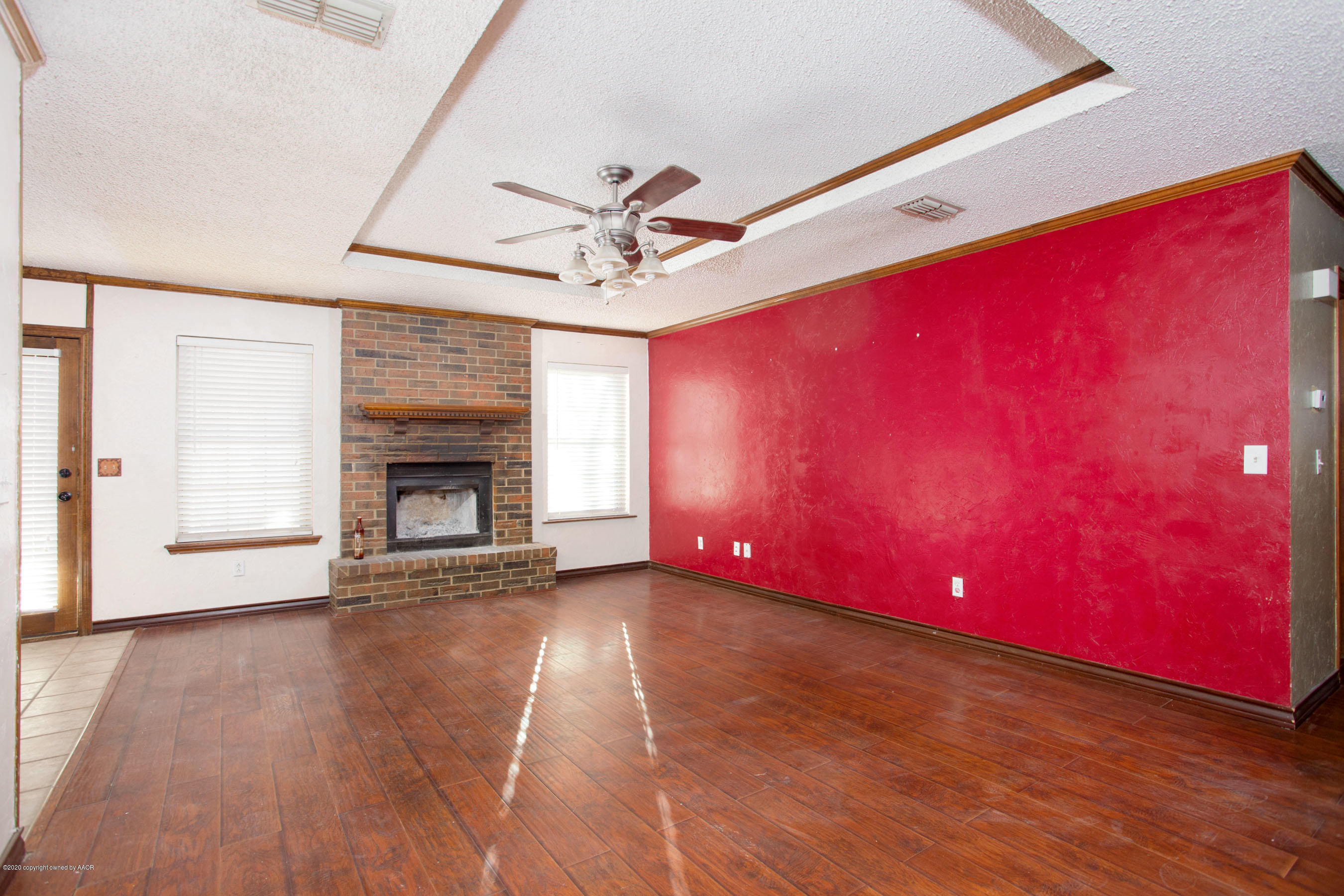 8213 Wrangler Trail Amarillo, TX 79110 - Photo 3 of 20 a view of empty room with wooden floor and fireplace