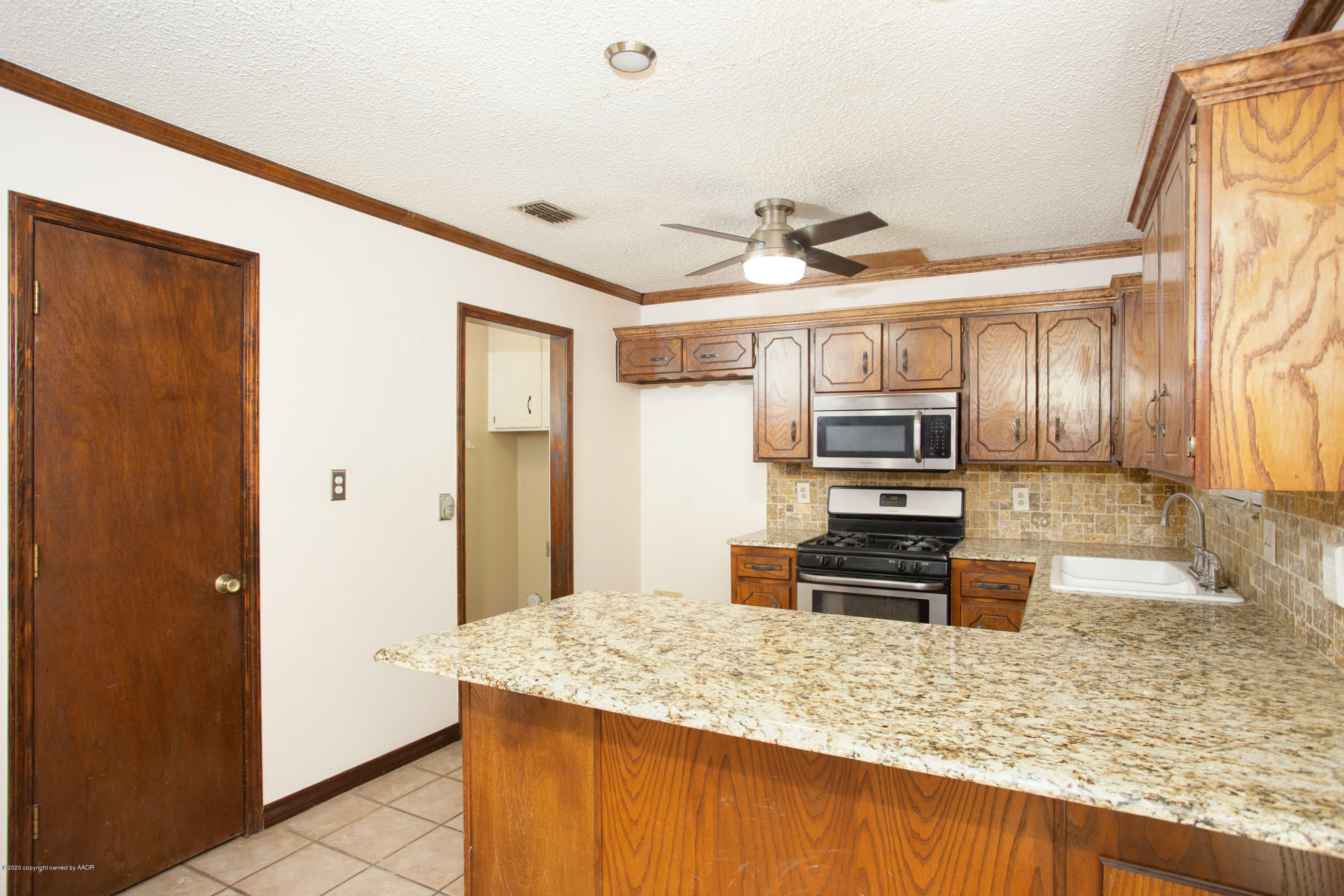 8213 Wrangler Trail Amarillo, TX 79110 - Photo 7 of 20 a kitchen with stainless steel appliances granite countertop a sink refrigerator and microwave
