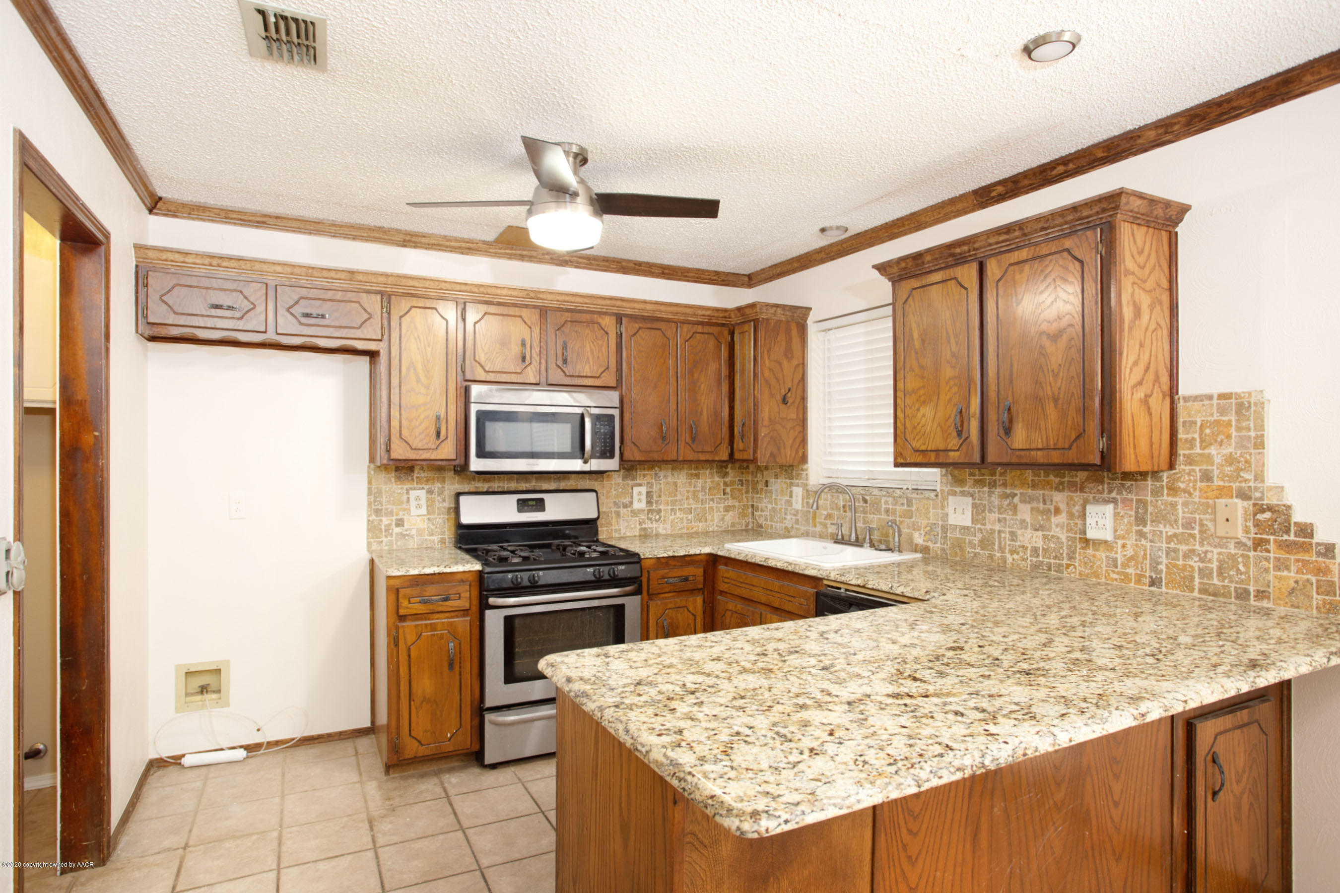 8213 Wrangler Trail Amarillo, TX 79110 - Photo 8 of 20 a kitchen with stainless steel appliances granite countertop a sink refrigerator and cabinets