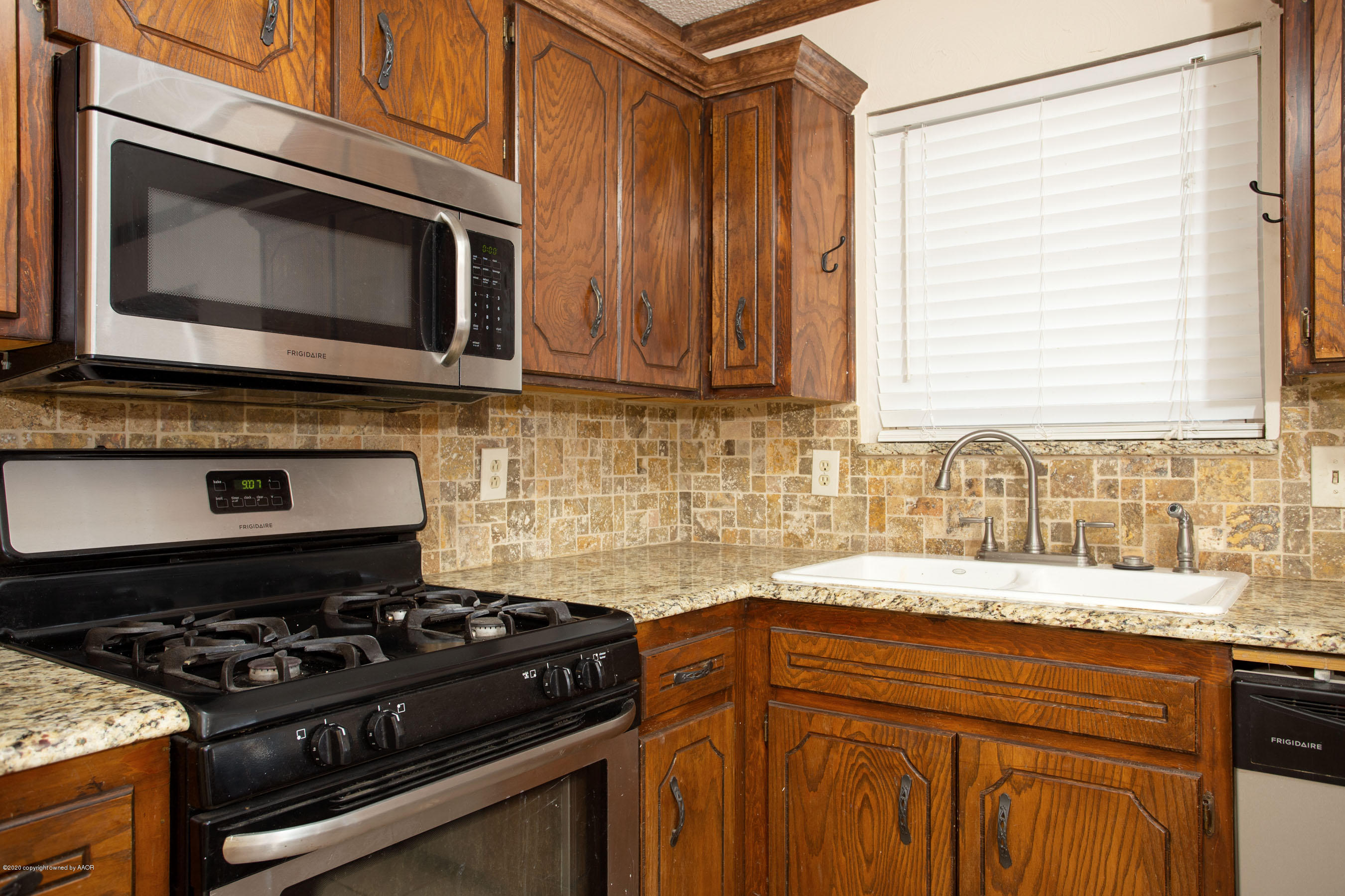 8213 Wrangler Trail Amarillo, TX 79110 - Photo 9 of 20 a kitchen with a stove and a microwave