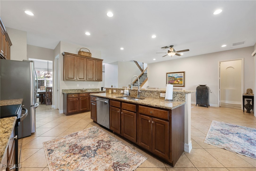 10117 Silver Maple Court Fort Myers, FL 33913 - Photo 12 of 49 a kitchen with stainless steel appliances granite countertop a sink stove and refrigerator