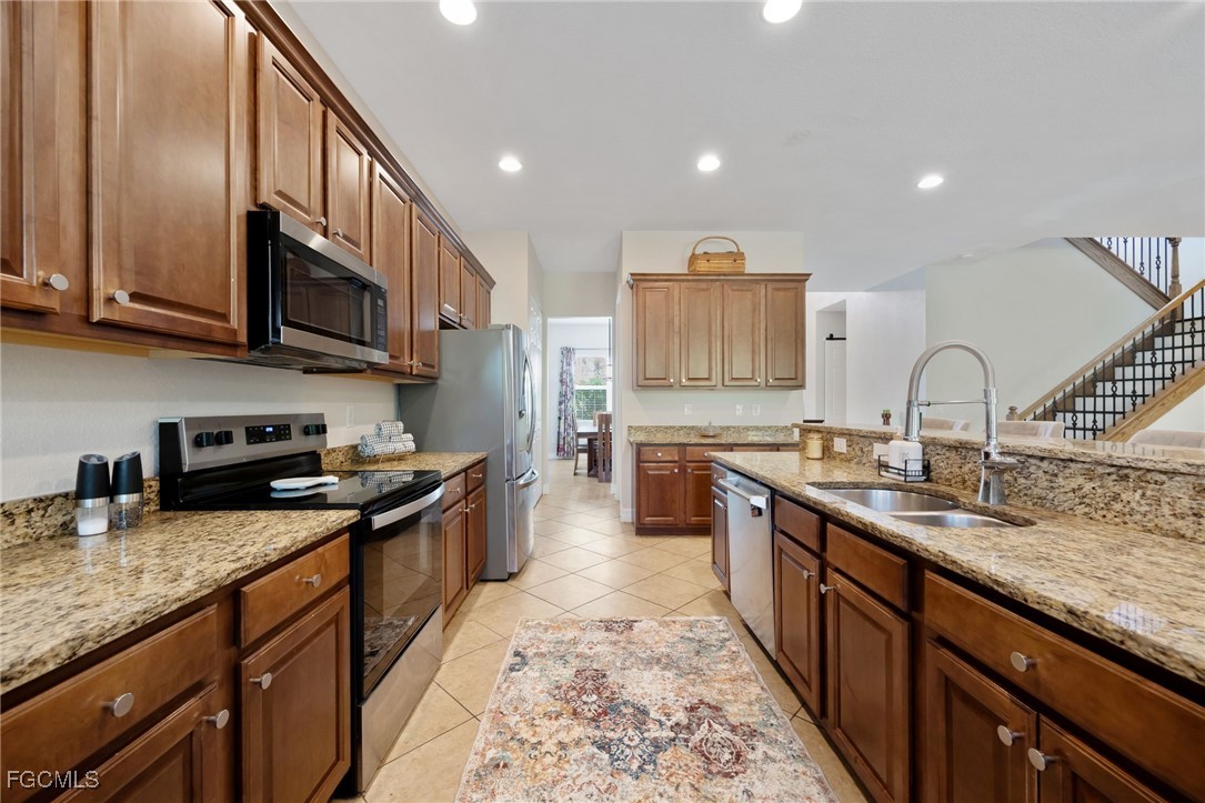10117 Silver Maple Court Fort Myers, FL 33913 - Photo 13 of 49 a kitchen with stainless steel appliances granite countertop a sink stove and cabinets