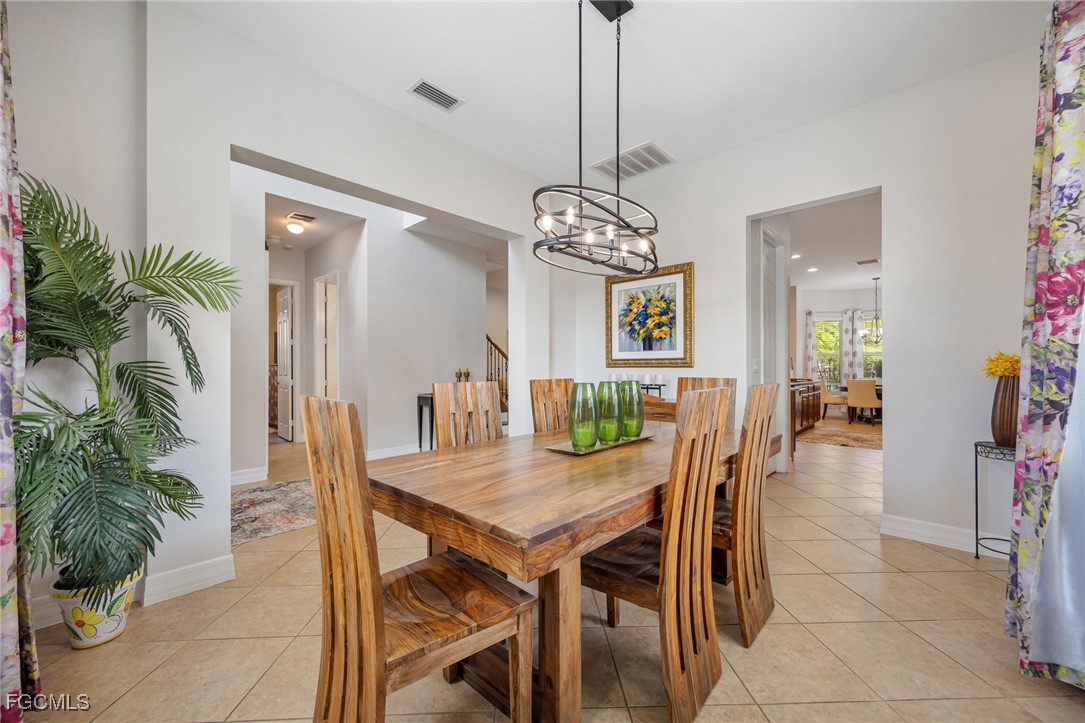 10117 Silver Maple Court Fort Myers, FL 33913 - Photo 18 of 49 a view of a dining room with furniture and chandelier