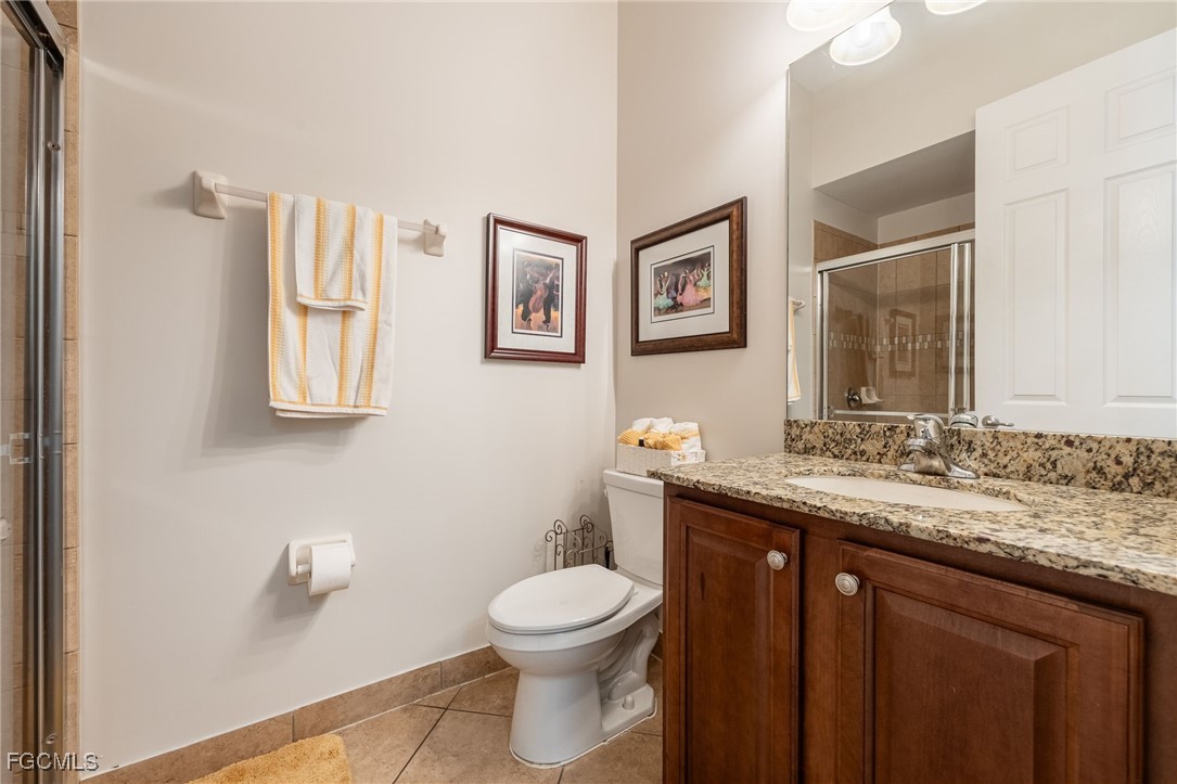 10117 Silver Maple Court Fort Myers, FL 33913 - Photo 23 of 49 a bathroom with a granite countertop toilet a sink and mirror
