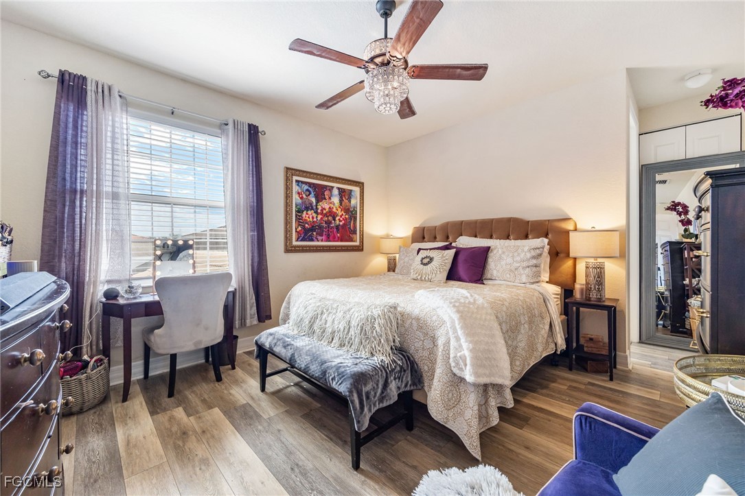 10117 Silver Maple Court Fort Myers, FL 33913 - Photo 26 of 49 a bedroom with a bed and wooden floor