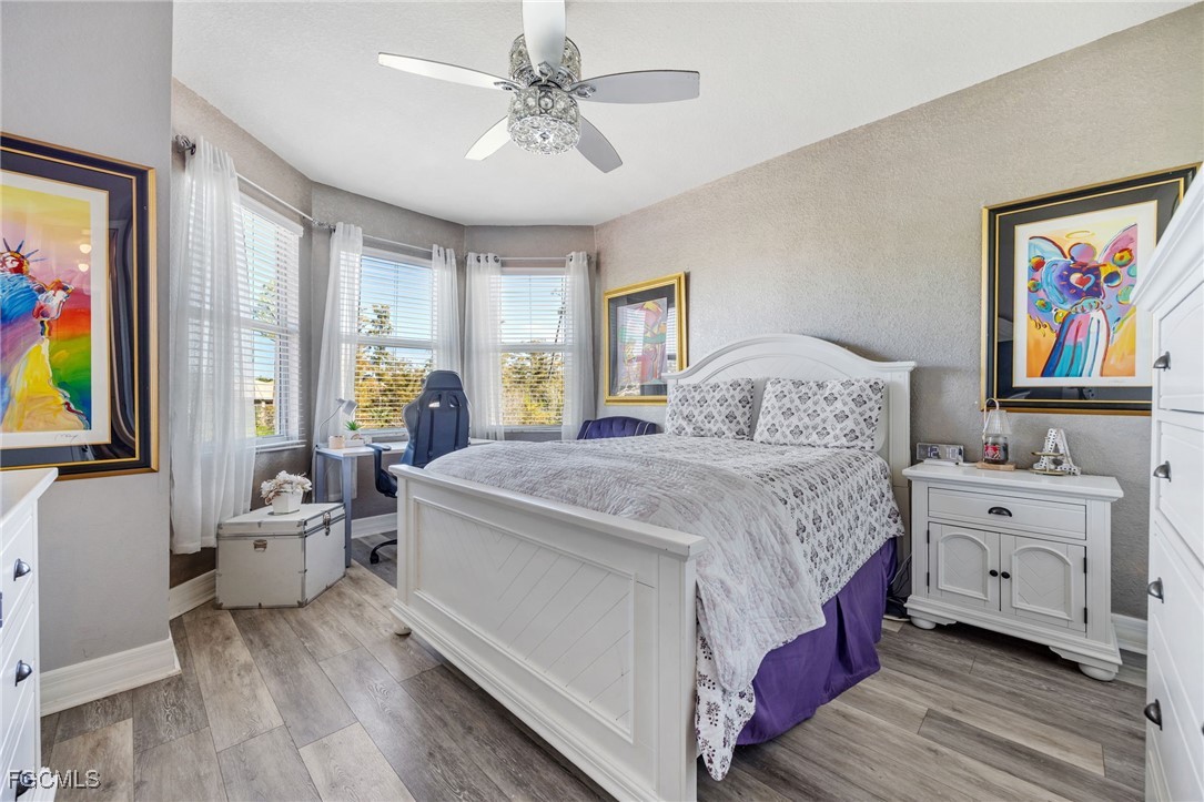 10117 Silver Maple Court Fort Myers, FL 33913 - Photo 28 of 49 a bedroom with a bed and a chandelier