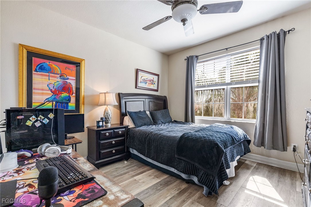 10117 Silver Maple Court Fort Myers, FL 33913 - Photo 30 of 49 a bedroom with a bed and wooden floor