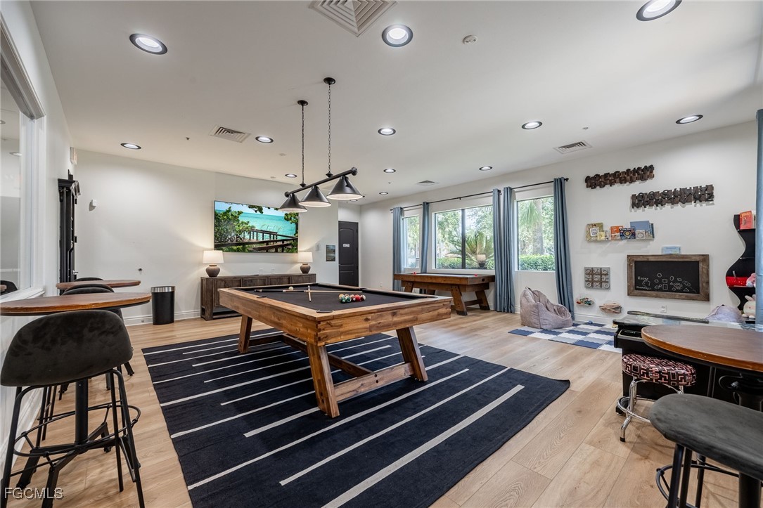 10117 Silver Maple Court Fort Myers, FL 33913 - Photo 48 of 49 a outdoor kitchen with a stove a sink dishwasher and a fireplace with wooden floor