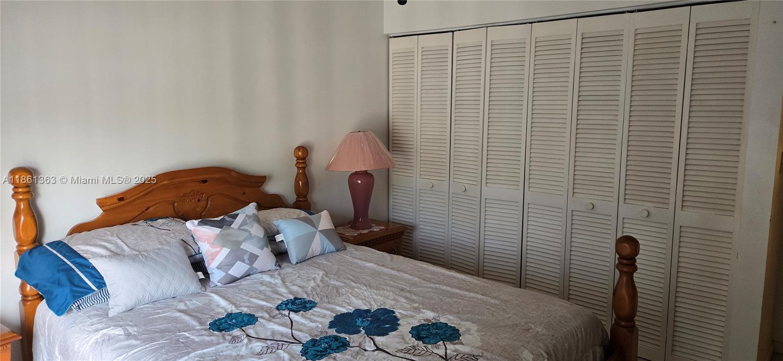 11034 Southwest 15th Manor, Unit X Davie, FL 33324 - Photo 4 of 5 a bedroom with a bed and a lamp