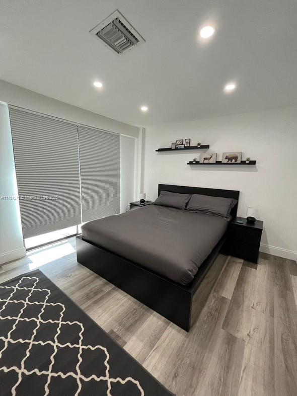 777 Southwest 9th Avenue, Unit 406 Miami, FL 33130 - Photo 2 of 11 a bedroom with a bed and wooden floor