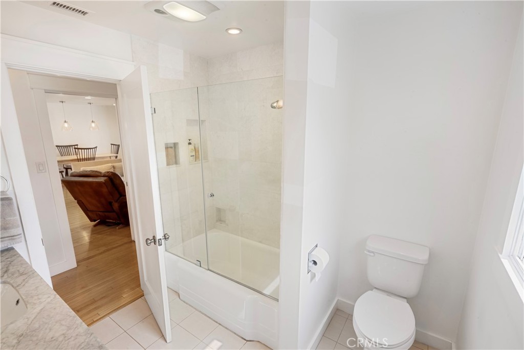 6736 Nicolett Street Riverside, CA 92504 - Photo 22 of 38 a bathroom with a granite countertop toilet and a shower