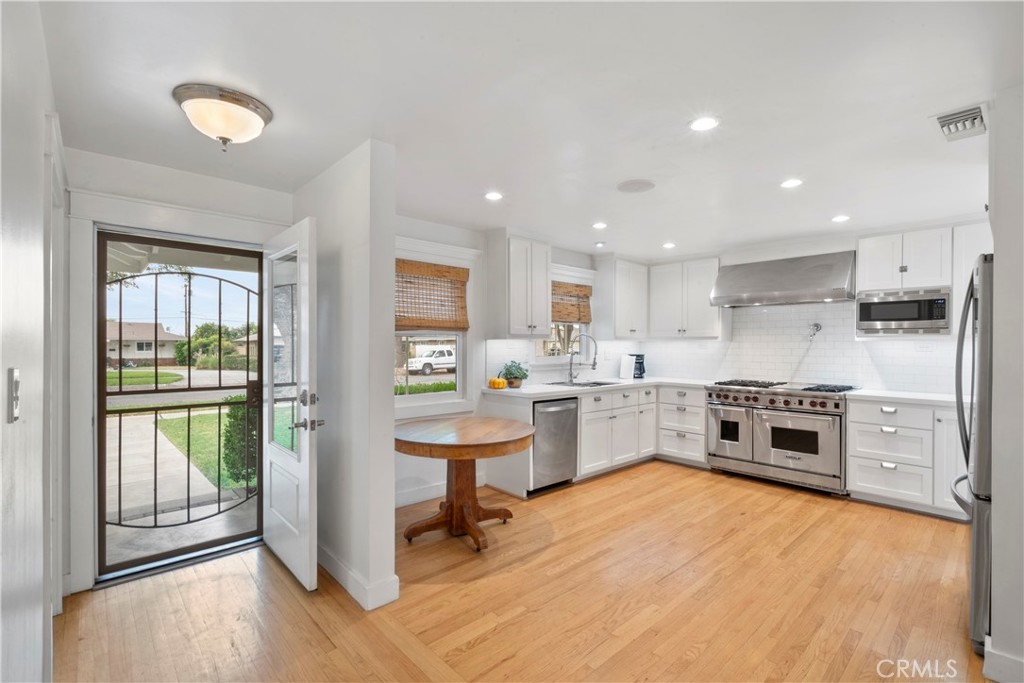 6736 Nicolett Street Riverside, CA 92504 - Photo 5 of 38 a kitchen with stainless steel appliances granite countertop a refrigerator oven a sink dishwasher and a stove with wooden floor