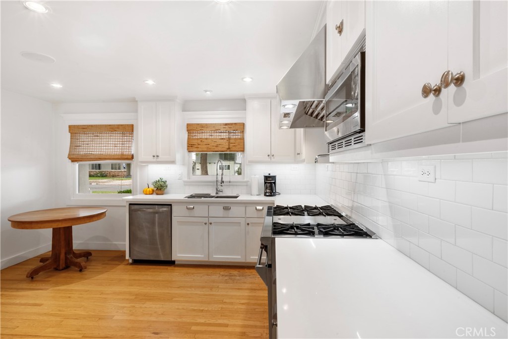 6736 Nicolett Street Riverside, CA 92504 - Photo 7 of 38 a kitchen with stainless steel appliances a sink a stove a refrigerator cabinets and living room view