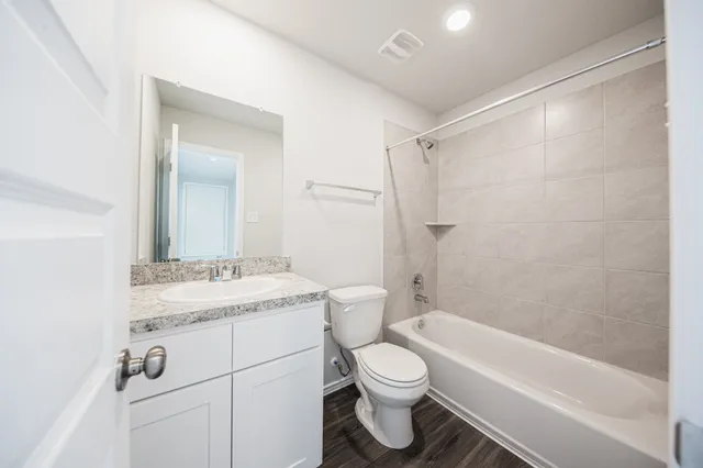 a bathroom with a granite countertop sink toilet a mirror and shower