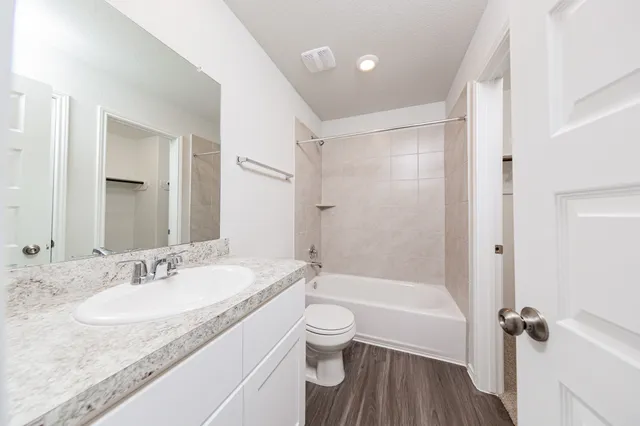 a bathroom with a granite countertop sink toilet and shower