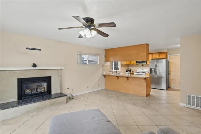 a view of a kitchen with a fireplace a sink and a living room