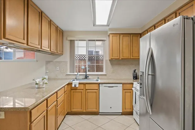 a kitchen with a sink refrigerator and cabinets