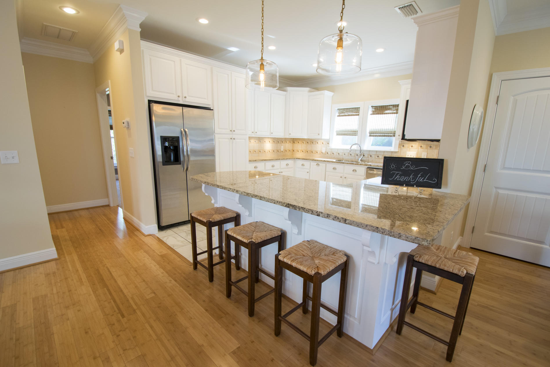 35 The Greenway Loop Inlet Beach, FL 32461 - Photo 11 of 37 a kitchen with stainless steel appliances granite countertop a refrigerator a oven a sink a dining table and chairs with wooden floor