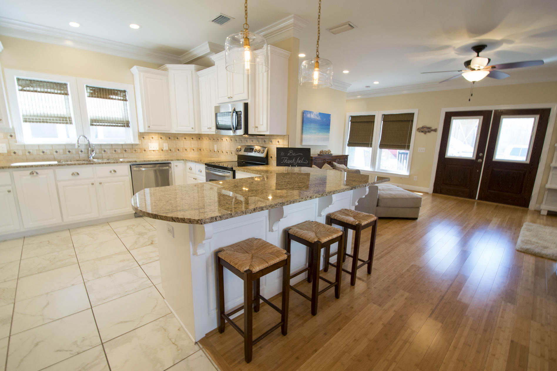 35 The Greenway Loop Inlet Beach, FL 32461 - Photo 12 of 37 a large kitchen with kitchen island a dining table chairs and a wooden floor