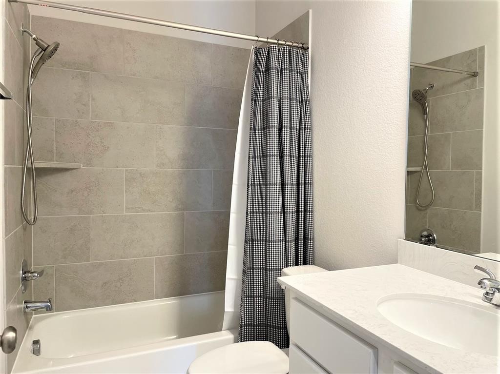 156 Santa Maria Street Georgetown, TX 78628 - Photo 22 of 40 Bathroom featuring a textured wall, vanity, and shower / bath combo with shower curtain