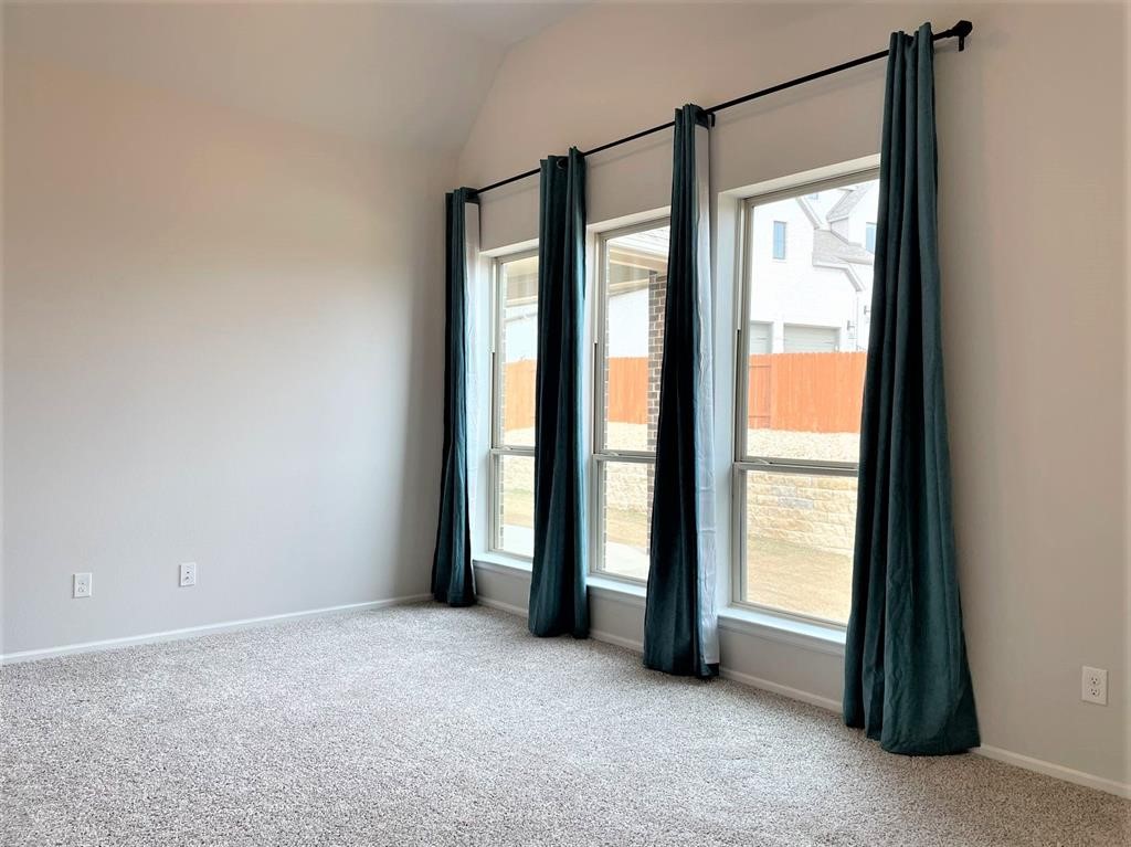 156 Santa Maria Street Georgetown, TX 78628 - Photo 26 of 40 Empty room featuring light carpet and vaulted ceiling