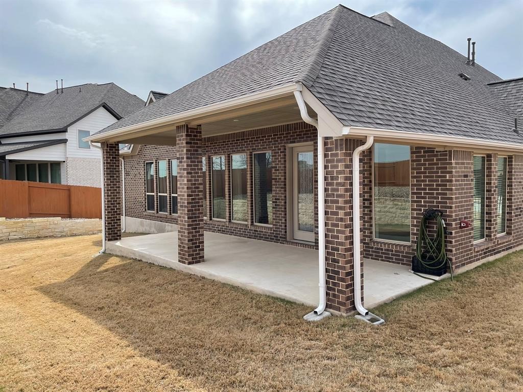 156 Santa Maria Street Georgetown, TX 78628 - Photo 34 of 40 Back of property with brick siding, roof with shingles, and a patio area