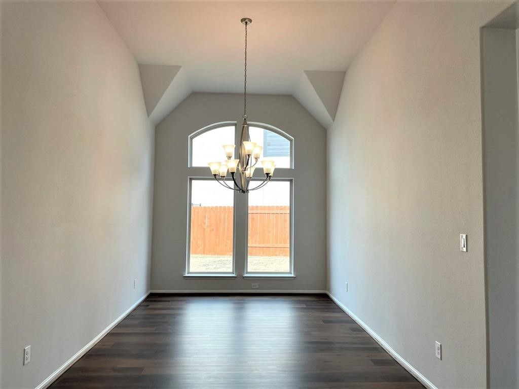 156 Santa Maria Street Georgetown, TX 78628 - Photo 7 of 40 Unfurnished dining area with a chandelier, lofted ceiling, and dark wood-type flooring