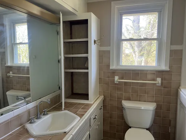 a bathroom with a toilet sink and mirror