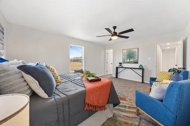 a living room with furniture and a ceiling fan