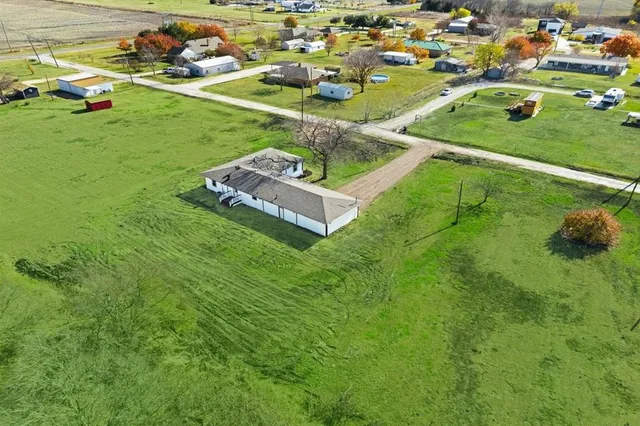 an aerial view of residential houses with outdoor space and trees
