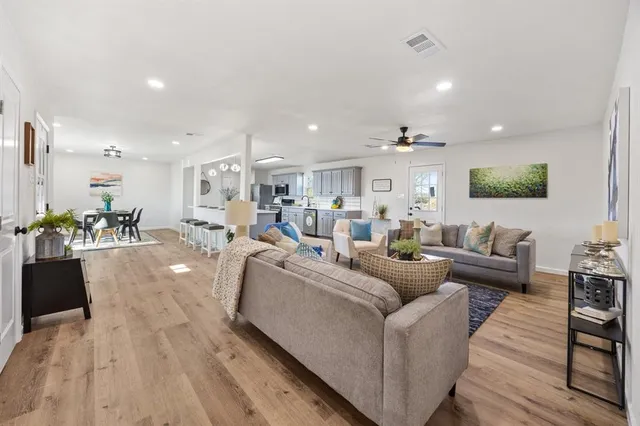 a living room with furniture and a wooden floor