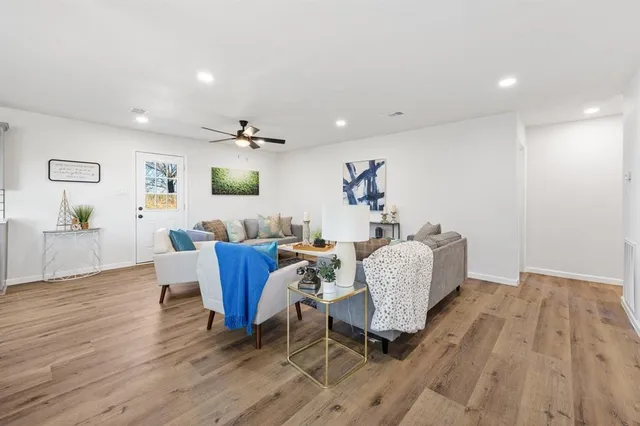 a living room with furniture and a wooden floor