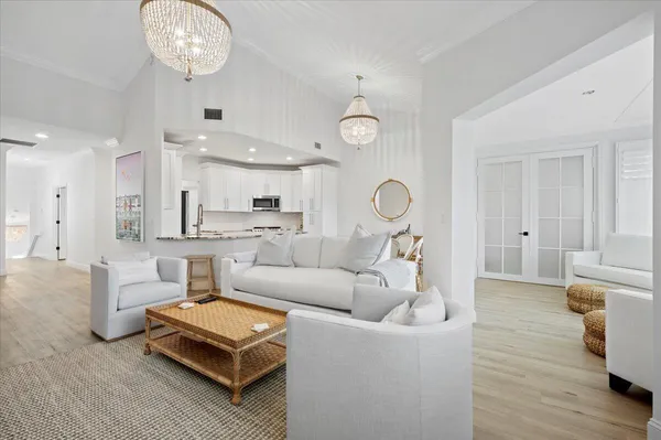 a living room with furniture a mirror and a chandelier