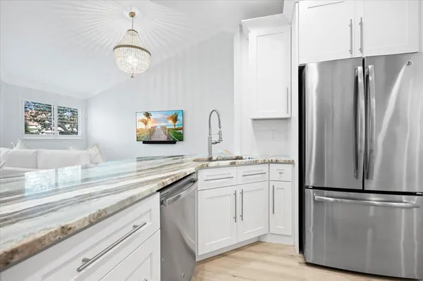 a kitchen with stainless steel appliances a refrigerator sink and microwave