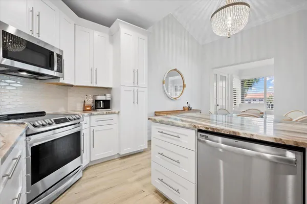 a kitchen with granite countertop a sink a stove oven and a white counter