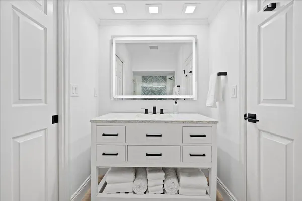 a bathroom with a sink mirror and