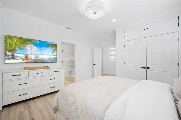 a spacious bedroom with a bed and a dresser