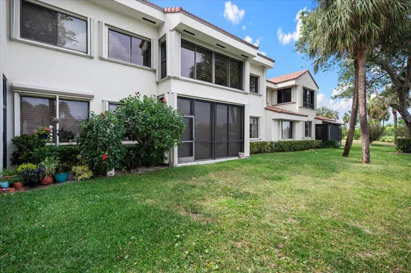 a view of a house with a yard and potted plants