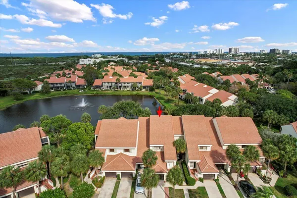 an aerial view of residential houses with outdoor space and lake view