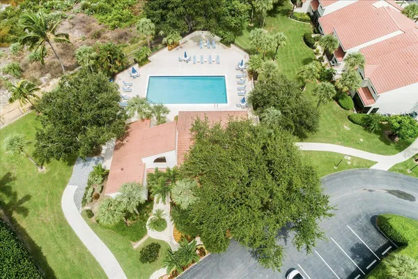an aerial view of a house with a yard and trees all around