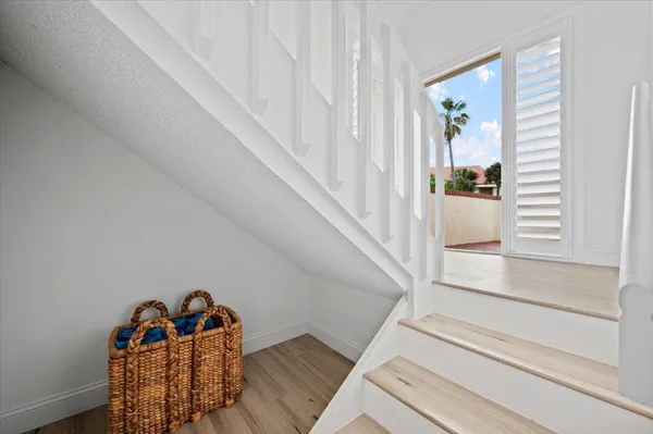 a view of a hallway to room with wooden floor and fireplace