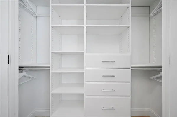 a view of walk in closet with empty racks