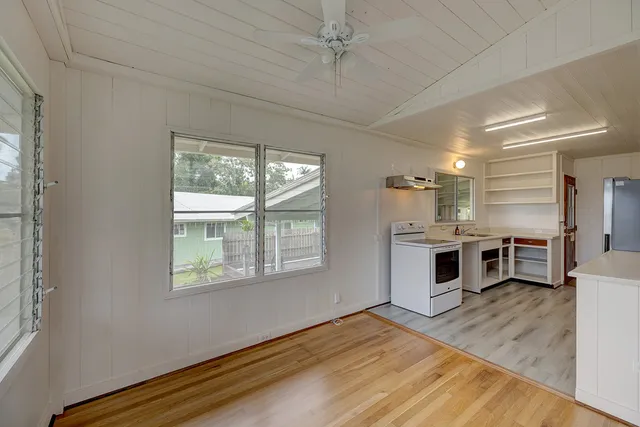 a kitchen with stainless steel appliances a white counter top space a stove and a window
