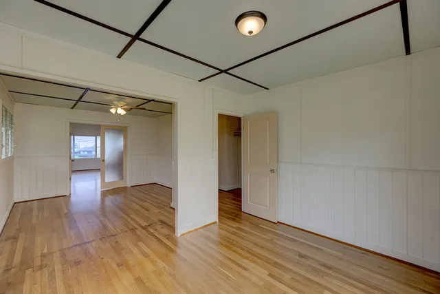 a view of empty room with wooden floor