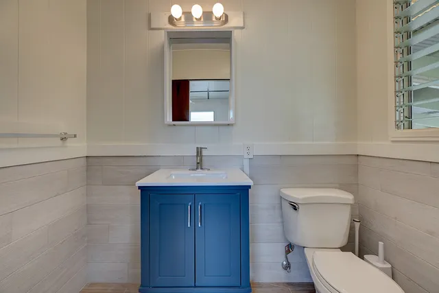 a bathroom with a toilet a sink and mirror