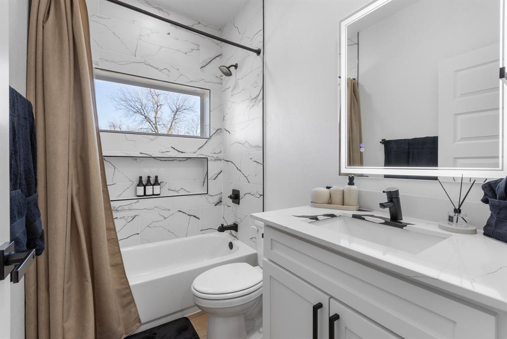 1511 Barry Avenue Dallas, TX 75223 - Photo 12 of 14 a bathroom with a sink a toilet and a mirror