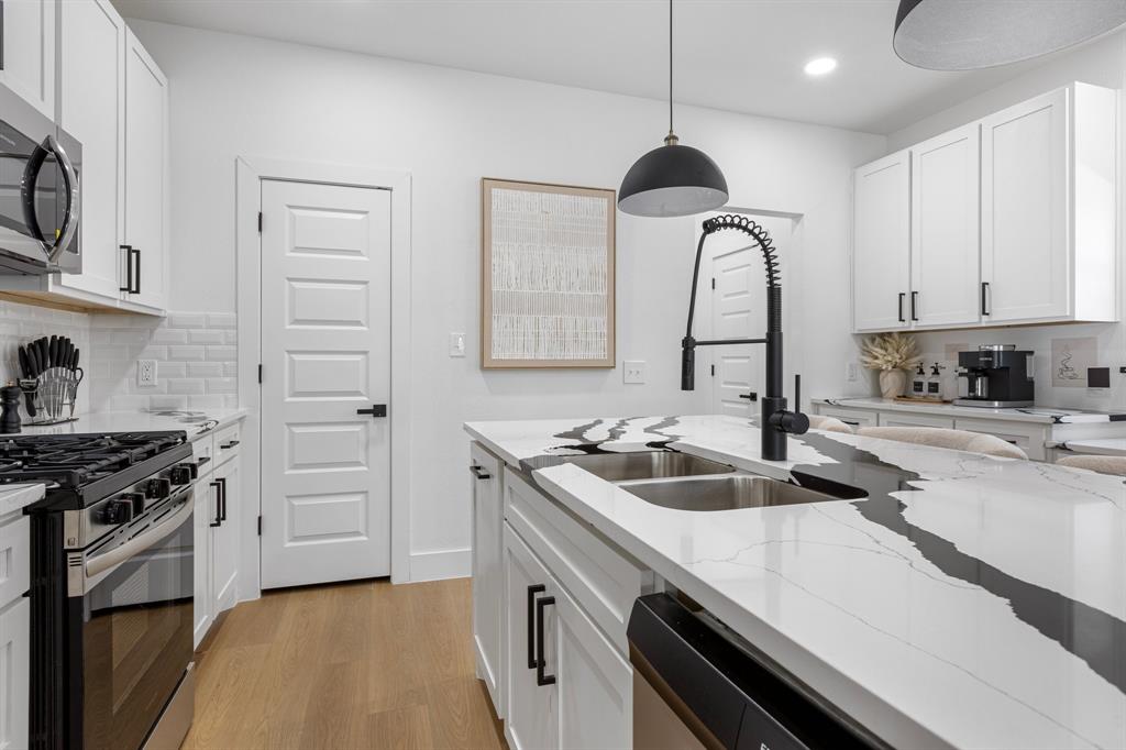 1511 Barry Avenue Dallas, TX 75223 - Photo 5 of 14 a kitchen with granite countertop a sink stainless steel appliances and cabinets