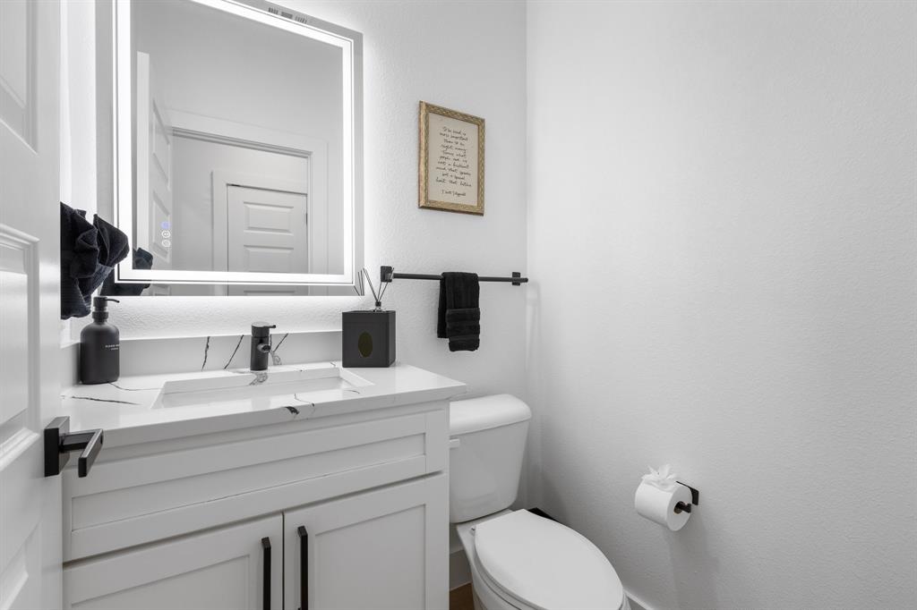 1511 Barry Avenue Dallas, TX 75223 - Photo 10 of 14 a bathroom with a sink mirror vanity and toilet