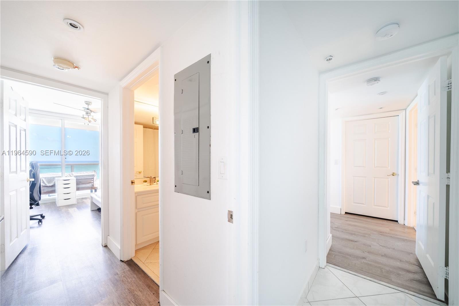 6301 Collins Avenue, Unit 2802 Miami Beach, FL 33141 - Photo 11 of 28 a view of a hallway with wooden floor and a bathroom