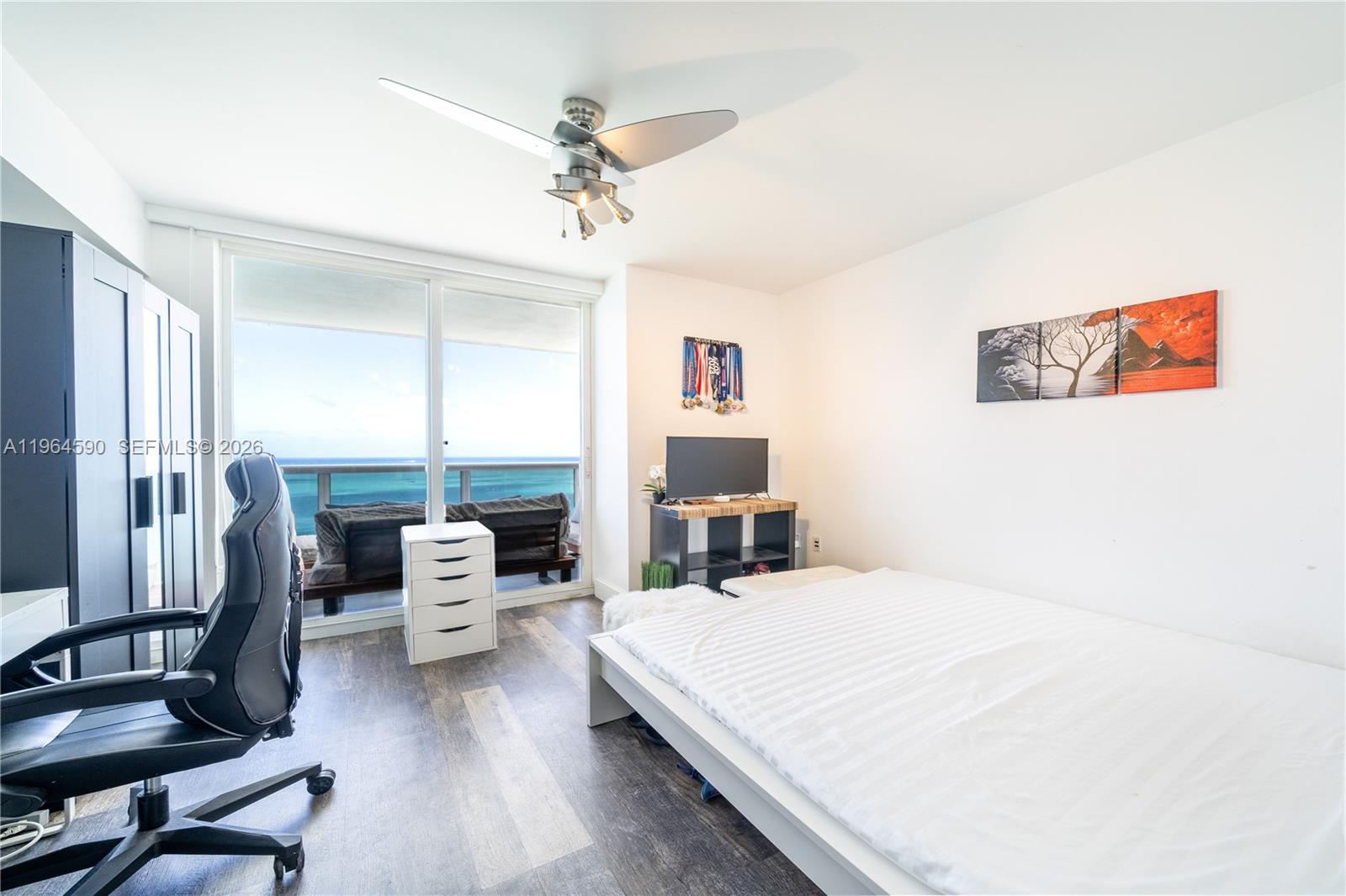 6301 Collins Avenue, Unit 2802 Miami Beach, FL 33141 - Photo 13 of 28 a bedroom with a bed and a chandelier